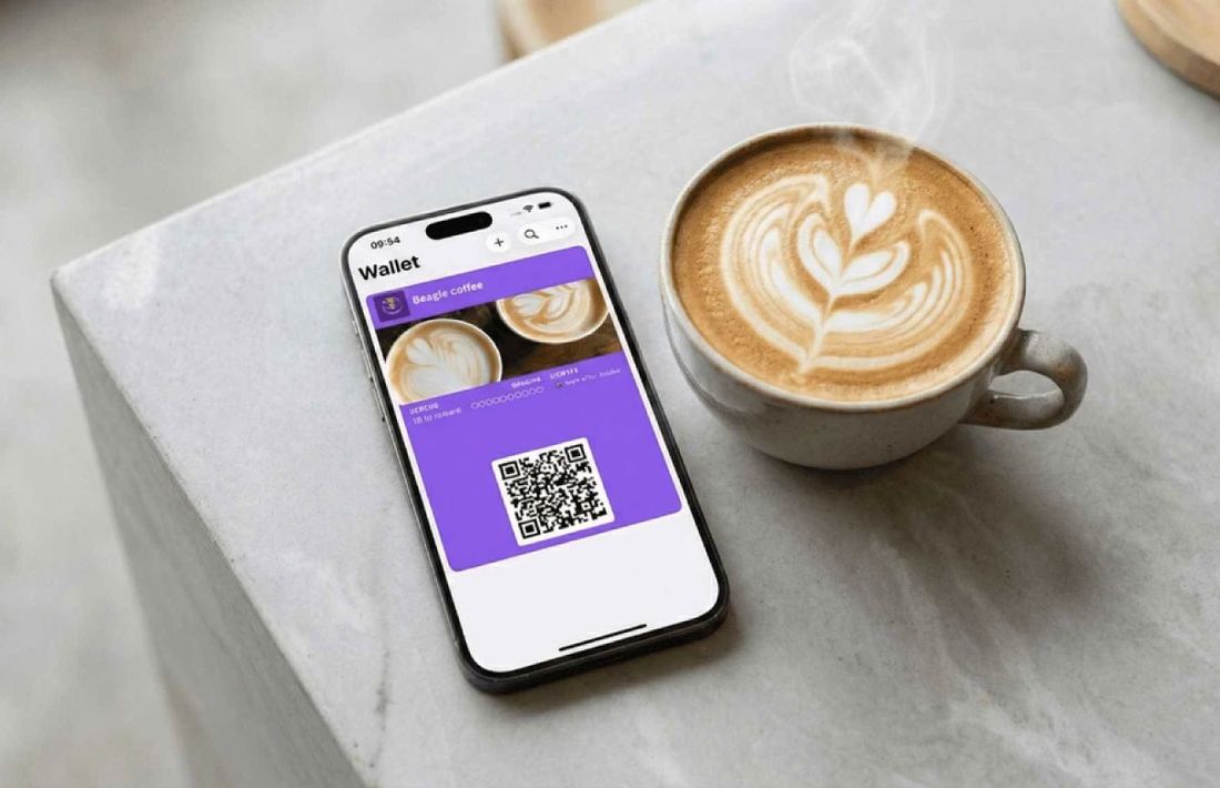 Celular con tarjeta de sellos junto a un café